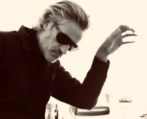 Der Pianist Kolja Gork mit Sonnenbrille, den Kopf gesenkt, eine Hand erhoben
