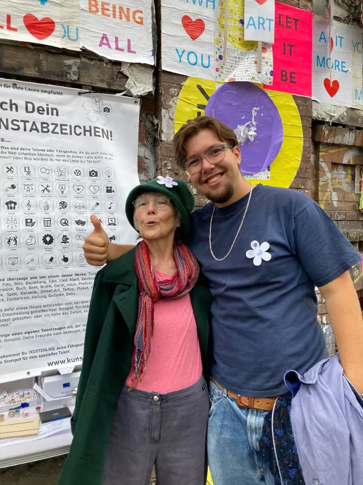 Oma und Enkel mit Kunstabzeichen vor der Kategorien-Tafel