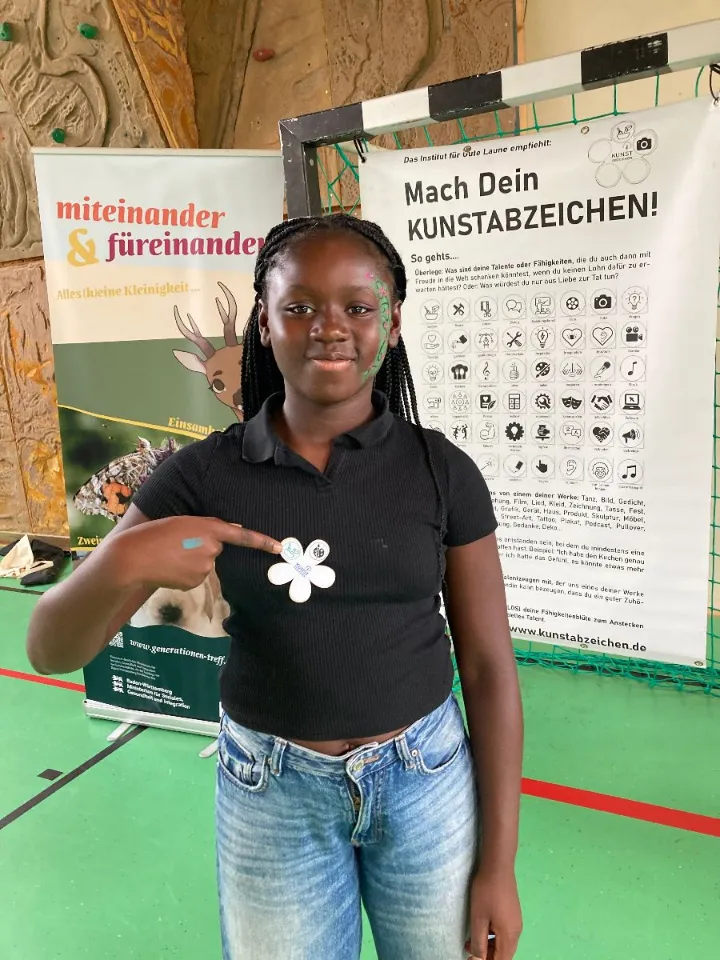 Mädchen zeigt auf ihr Kunstabzeichen