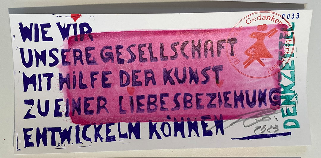 Gedruckte Karte, handgesetzte blaue Lettern: Wie wir unsere Gesellschaft mit Hilfe der Kunst zu einer Liebesbeziehung entwickeln können. Quer darüber ein pinker Farbstrich, rechts ein roter Stempel und das Wort Denkzettel.