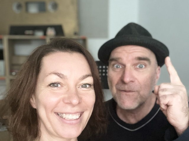 Die beiden Podcast-Stimmen: eine Frau und ein Mann mit schwarzer Mütze, der den Zeigefinger hebt.
