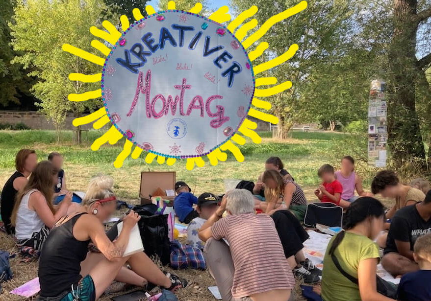 Menschen sitzen an einem Sommerabend auf der Wiese und arbeiten an eigenen Projekten. Über ihnen ein gemaltes Sonnenschild mit der Aufschrift Kreativer Montag.